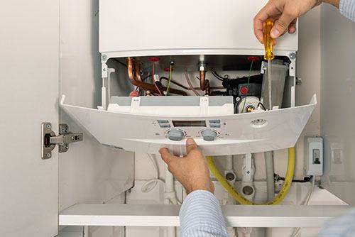 HVAC technician repairing an indoor boiler in Frederick