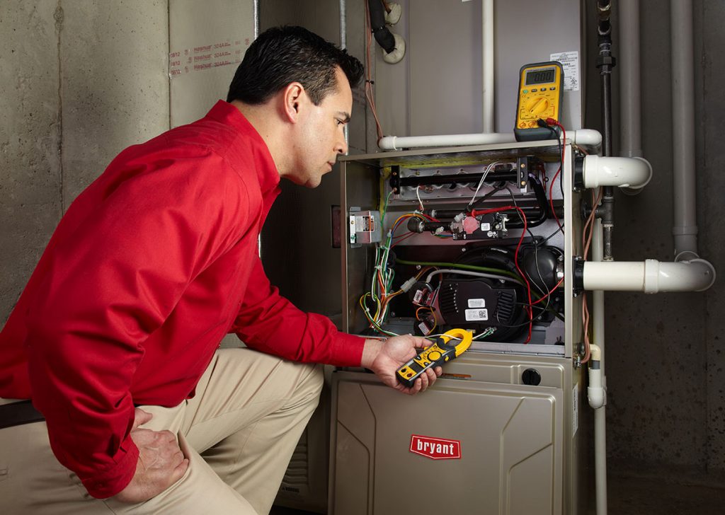 HVAC technician repairing an indoor furnace in Frederick