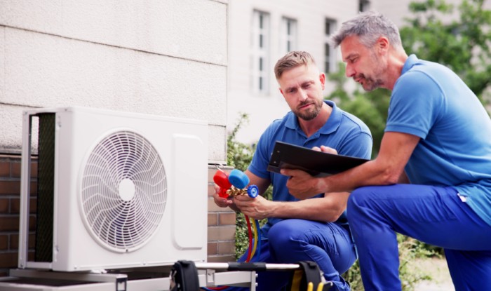 HVAC technicians installing an outdoor air conditioning unit in Frederick