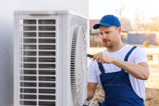 HVAC technician servicing an outdoor air conditioning unit in Frederick