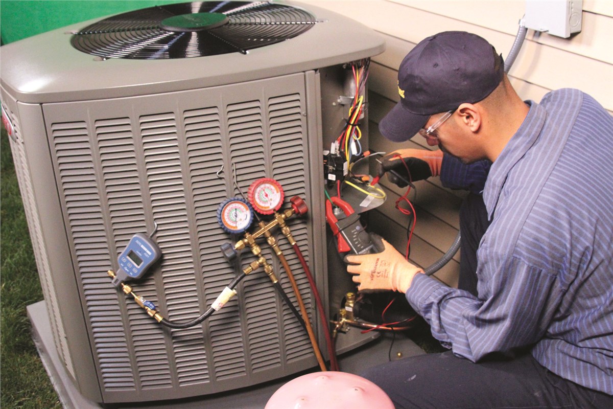 HVAC technician testing an outdoor air conditioning unit in Frederick