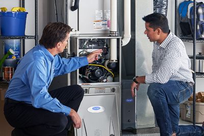 65df8c11f3e4c468cbd351a5_furnace repair vs replacement – Copy HVAC technician explaining furnace repair and maintenance to a homeowner in Frederick, CO