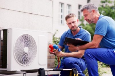 ac-installation-in-claremont-ca HVAC technicians reviewing an outdoor air conditioning unit in Frederick, CO