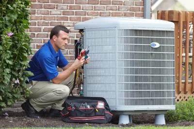 design-air-heating-and-air-conditioning-decatur-il-05 – Copy HVAC technician inspecting an outdoor air conditioning unit in Frederick, CO